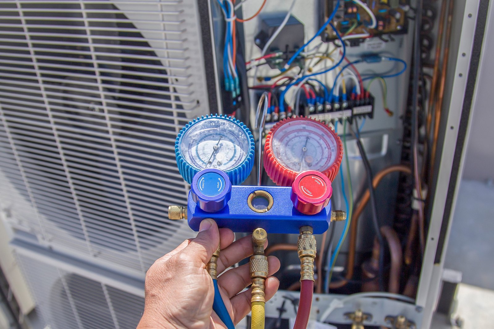 An AC TO THE MAX, INC HVAC technician using a manifold gauge to perform an AC repair diagnostics check in Phoenix, AZ.